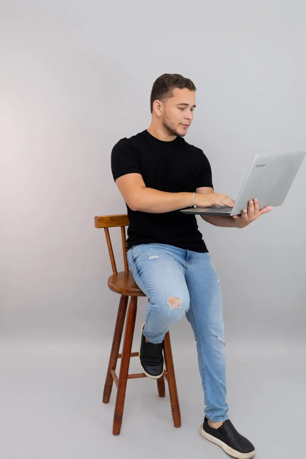 Luiz Henrique sentado, trabalhando na edição com um notebook.